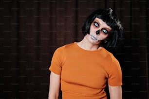 a woman wearing a skeleton make up and orange shirt