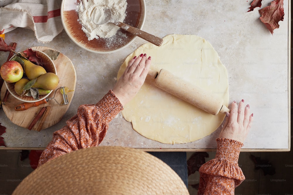a woman rolling out dough on a table