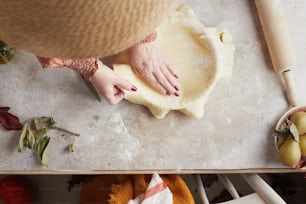 a person is kneading dough on a table