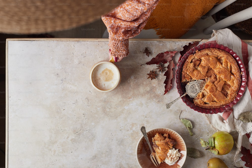 a table topped with a pie and a bowl of fruit