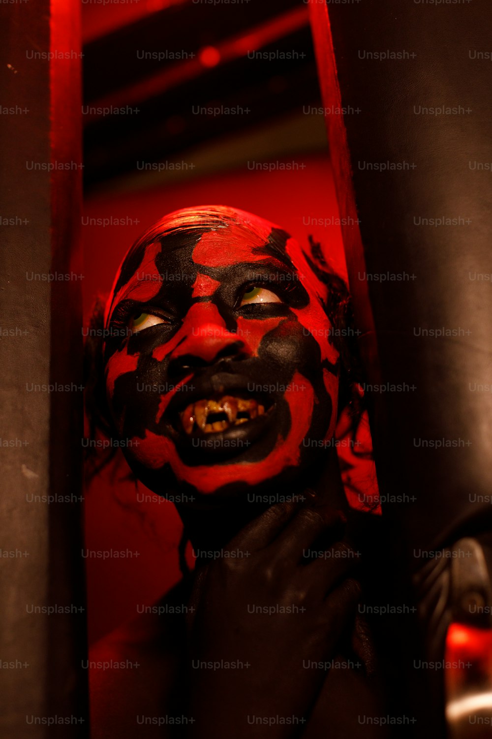a person with a red and black face painted