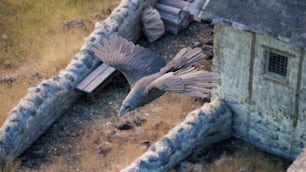 a bird flying over a building in a field