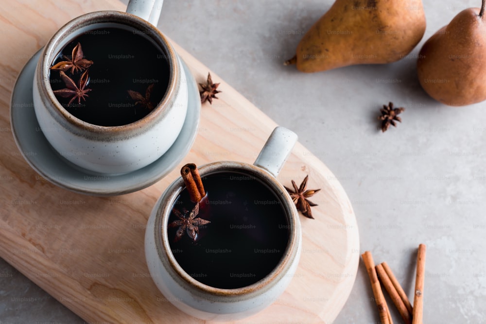 two cups of hot chocolate with cinnamon sticks