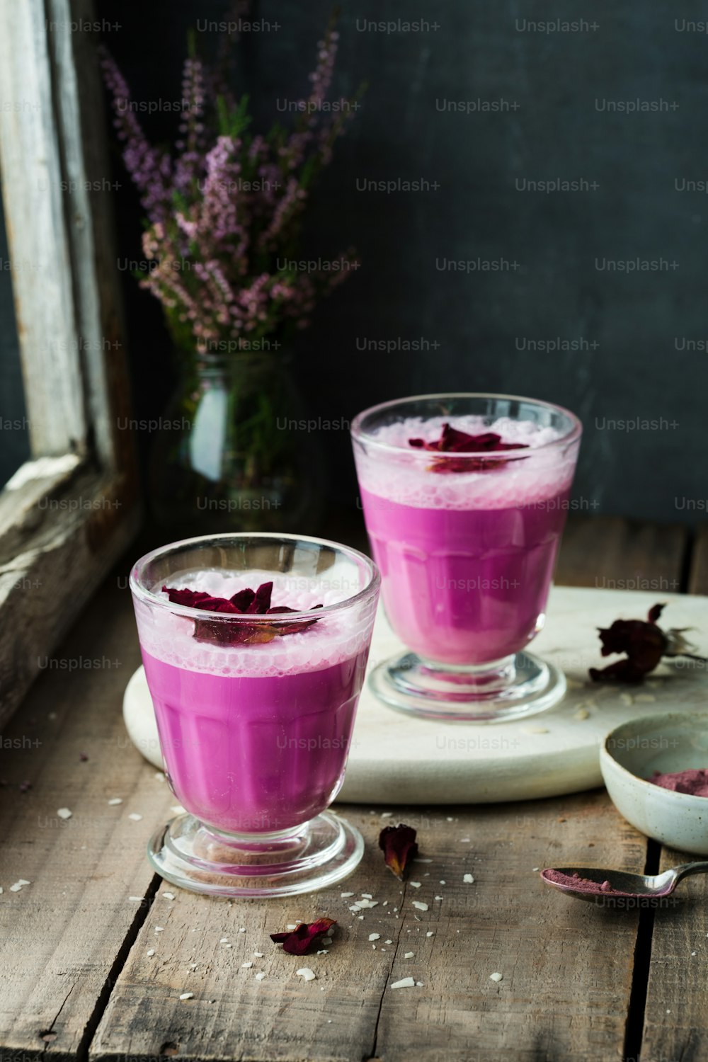 a couple of glasses filled with liquid on top of a wooden table