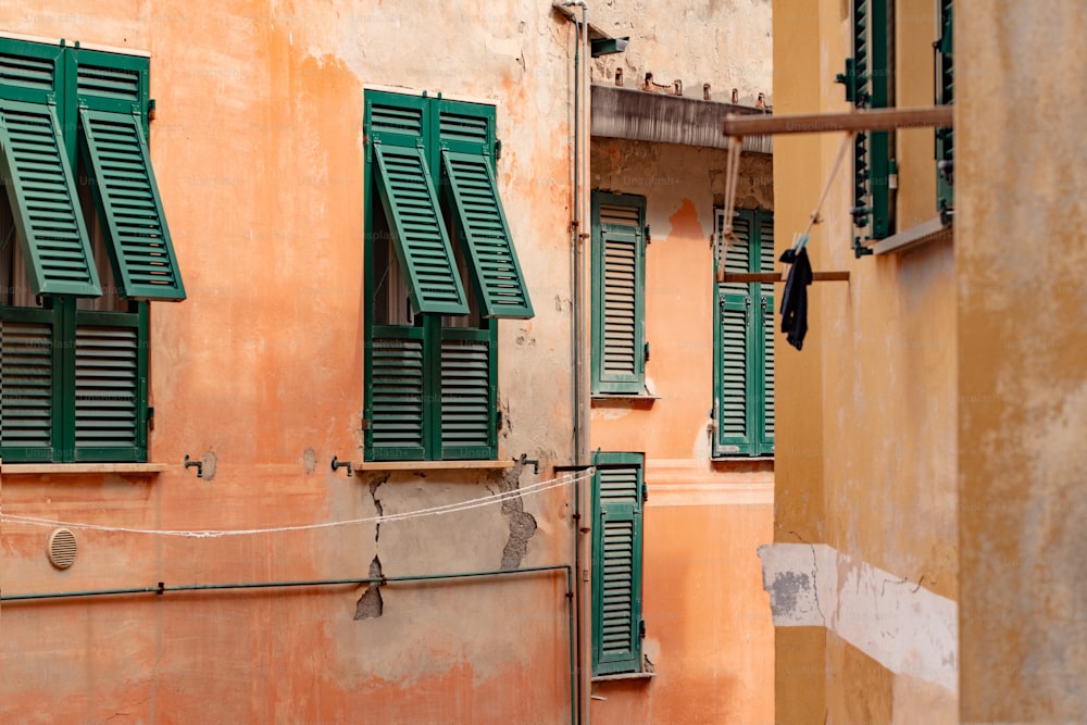 a couple of windows with green shutters on a building