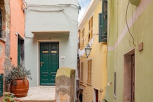 a narrow alleyway with a green door and green shutters