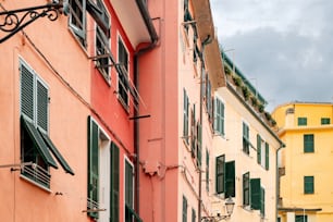 Eine Reihe bunter Gebäude mit grünen Fensterläden