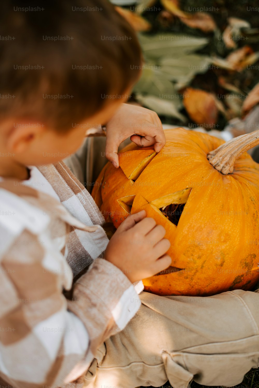 a young boy carving a pumpkin for halloween