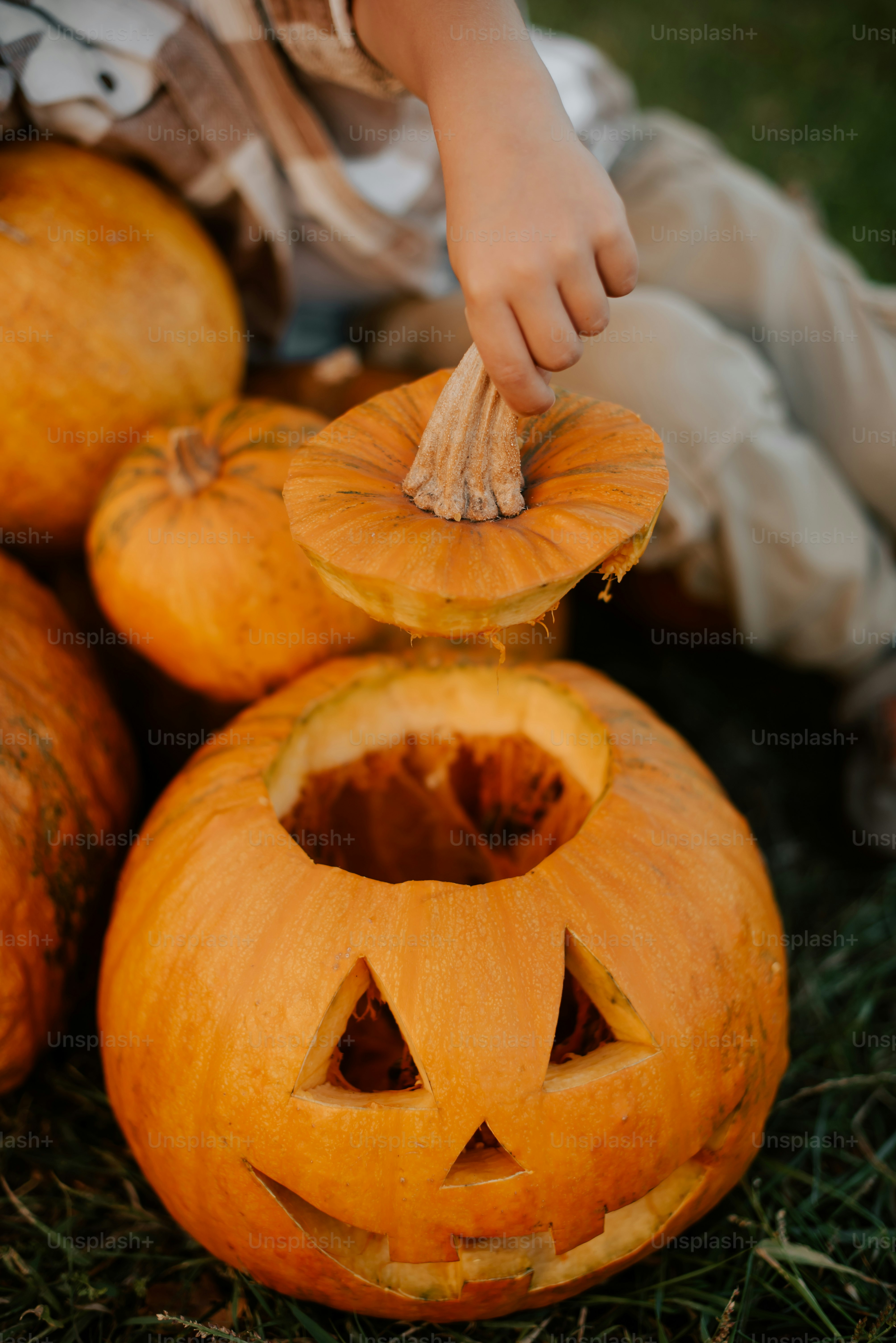 a young boy is carving a jack - o - lantern pumpkin