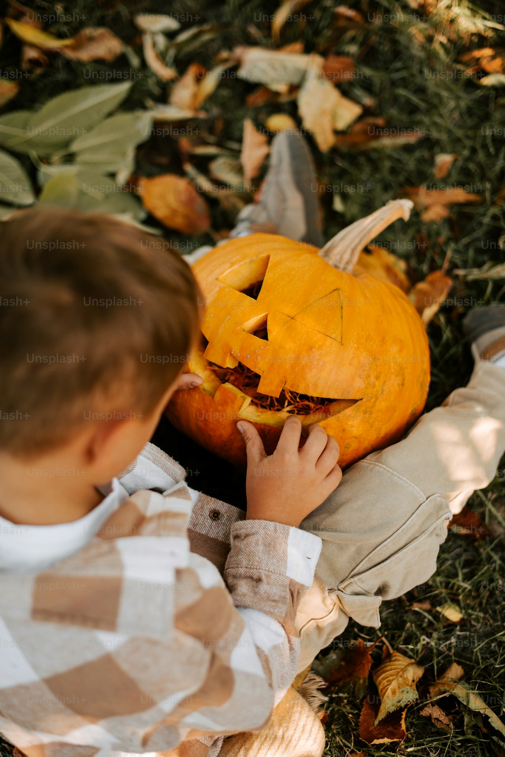 a young boy carving a pumpkin for halloween