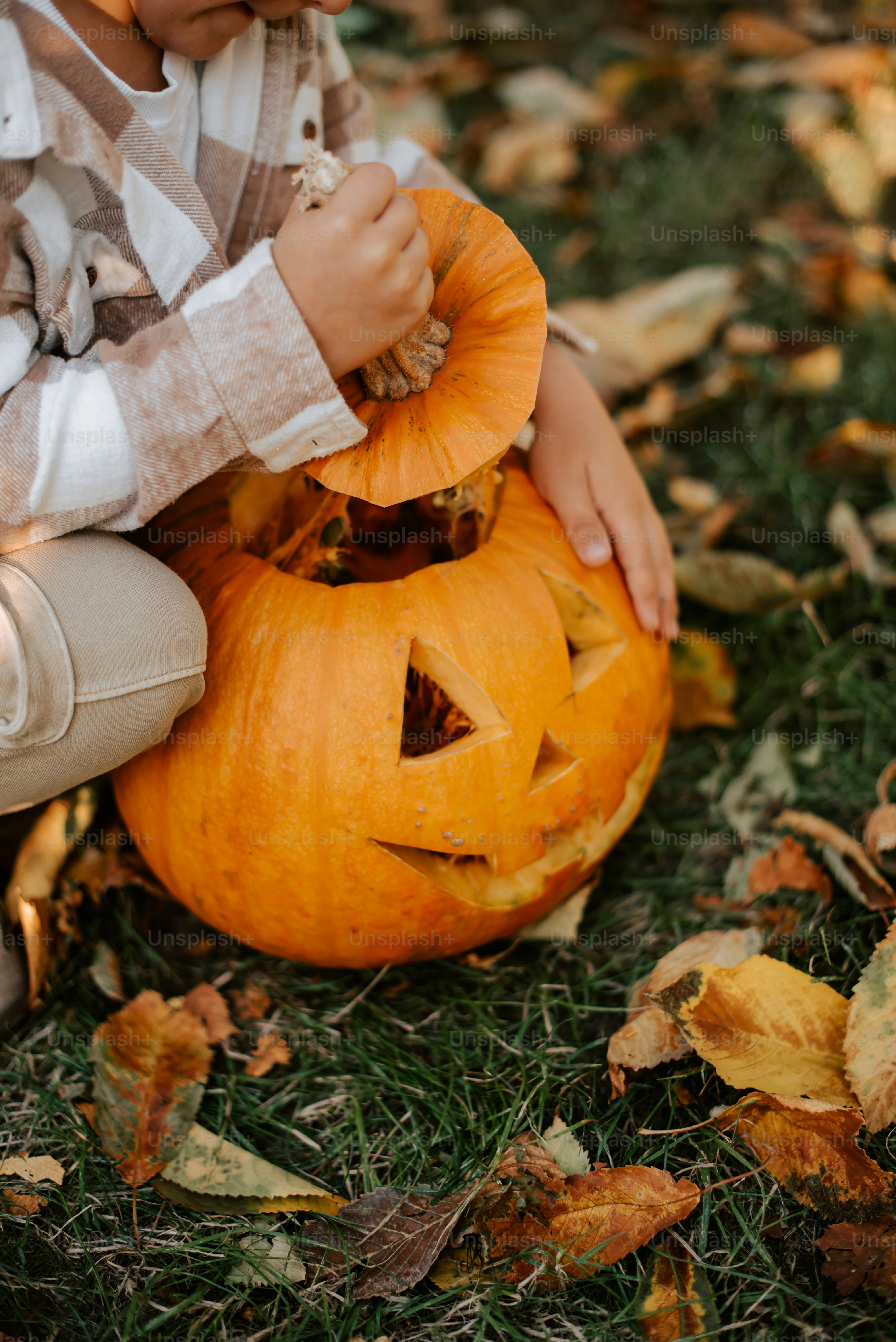 a young boy carving a pumpkin for halloween