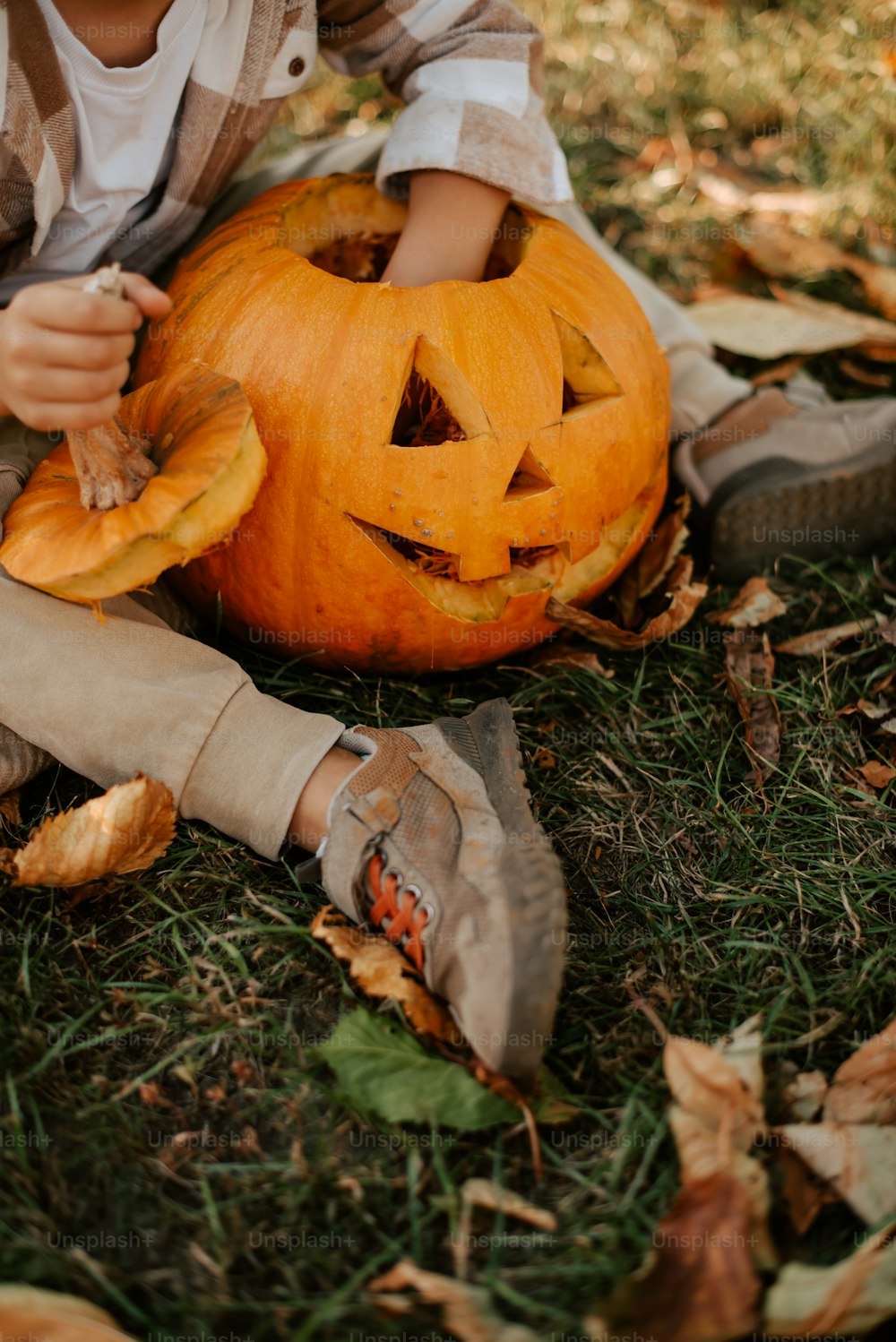 a young boy carving a pumpkin with a knife