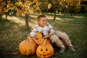 a young boy sitting on top of three pumpkins