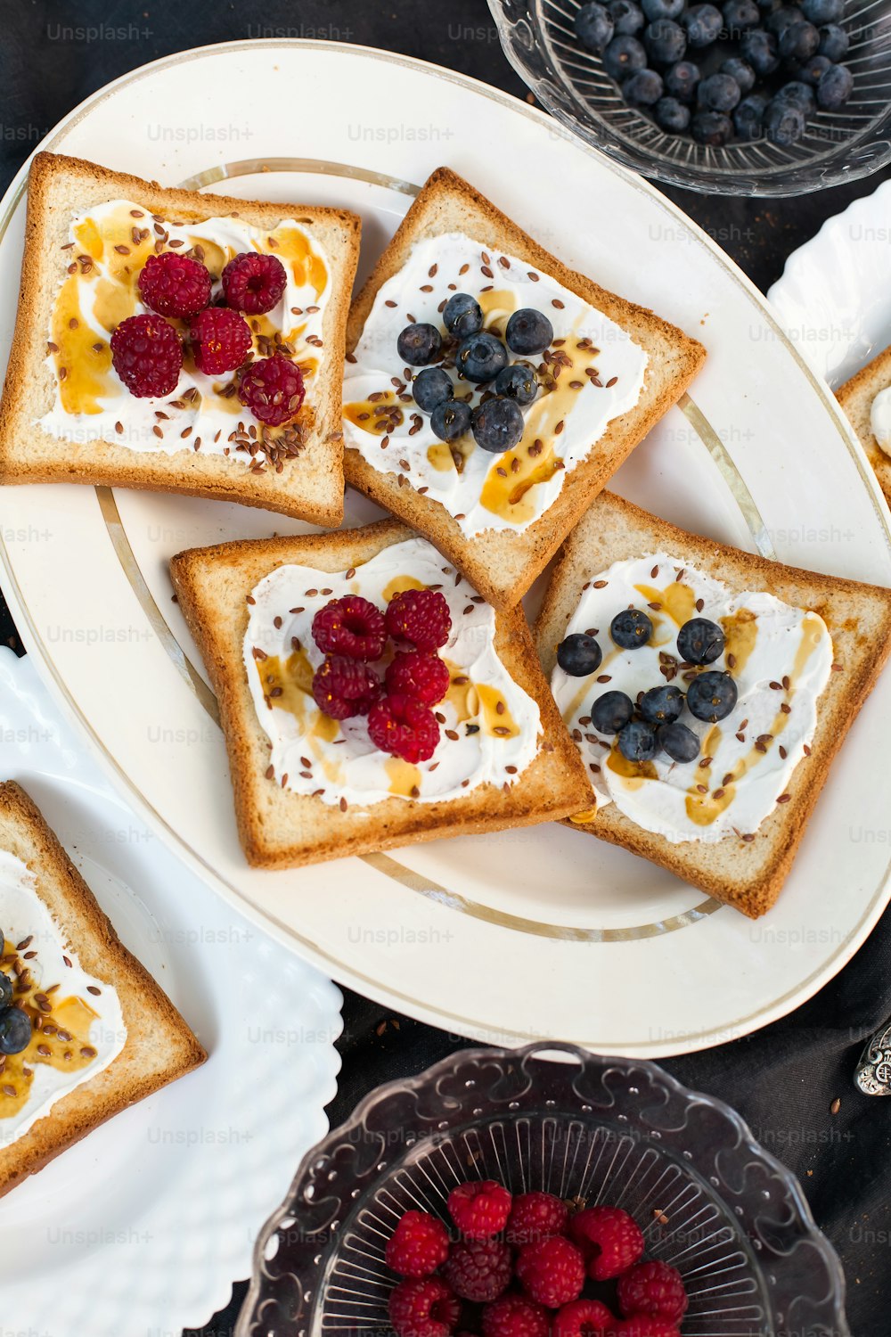 a white plate topped with slices of toast covered in fruit