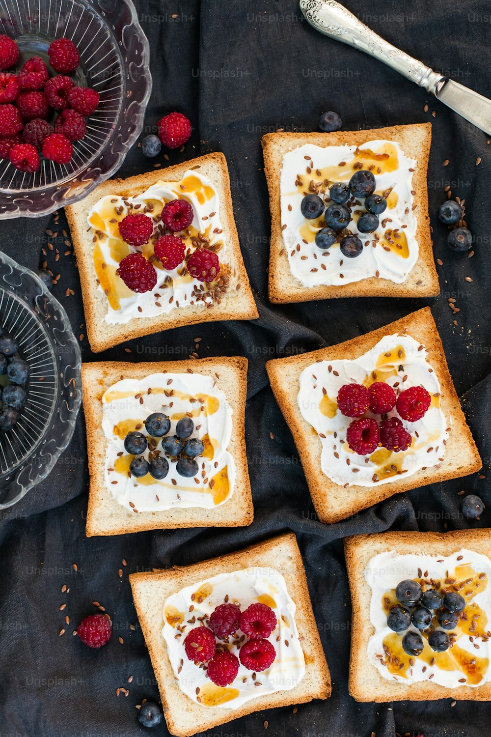 four pieces of toast topped with fruit and cream