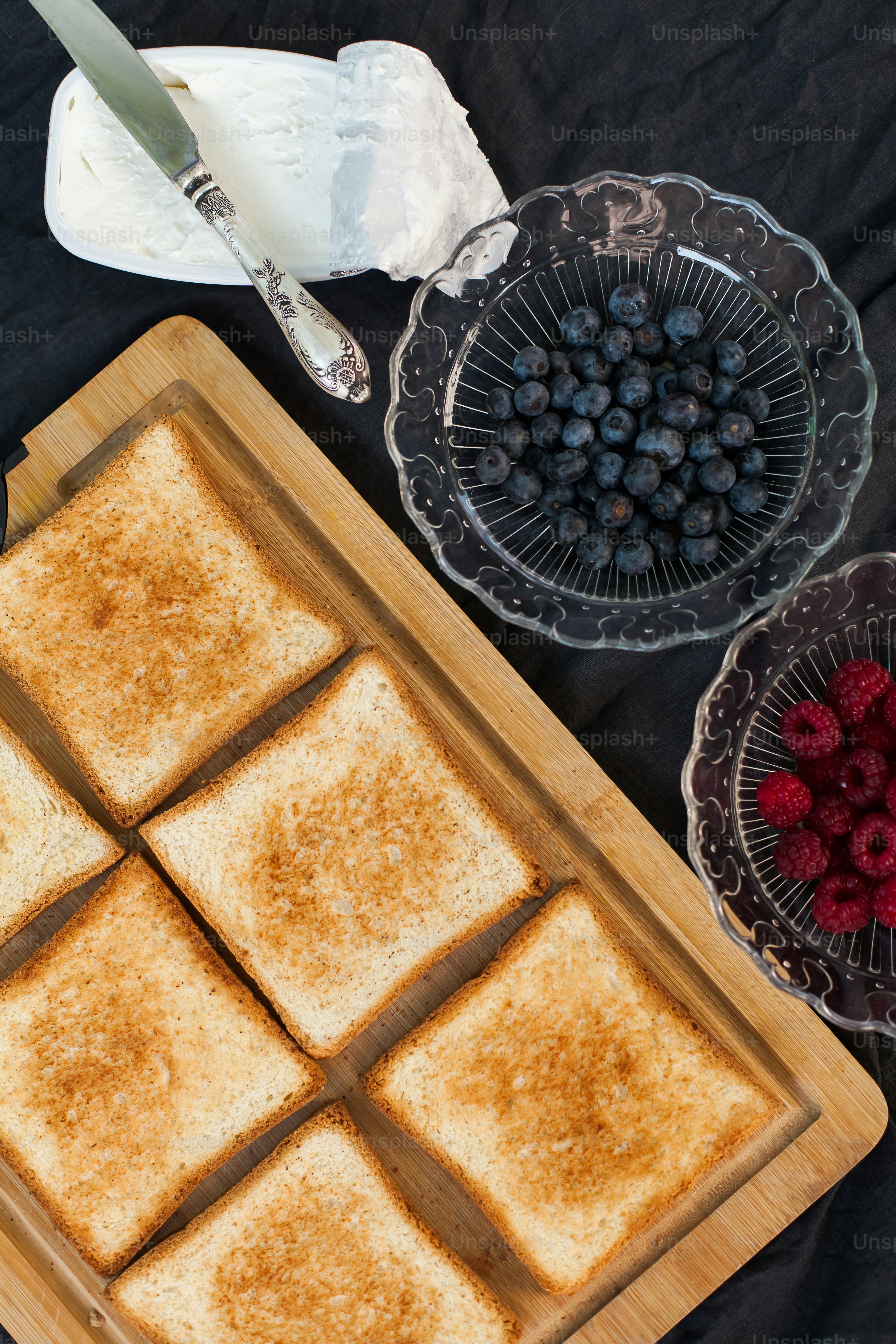 a wooden cutting board topped with four pieces of toast