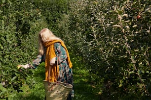 a woman walking through a field carrying a basket