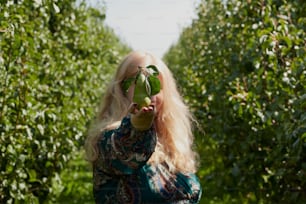 a woman holding a green apple up to her face