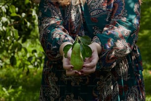 a woman holding a green leaf in her hands