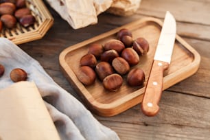 a wooden cutting board topped with nuts next to a knife