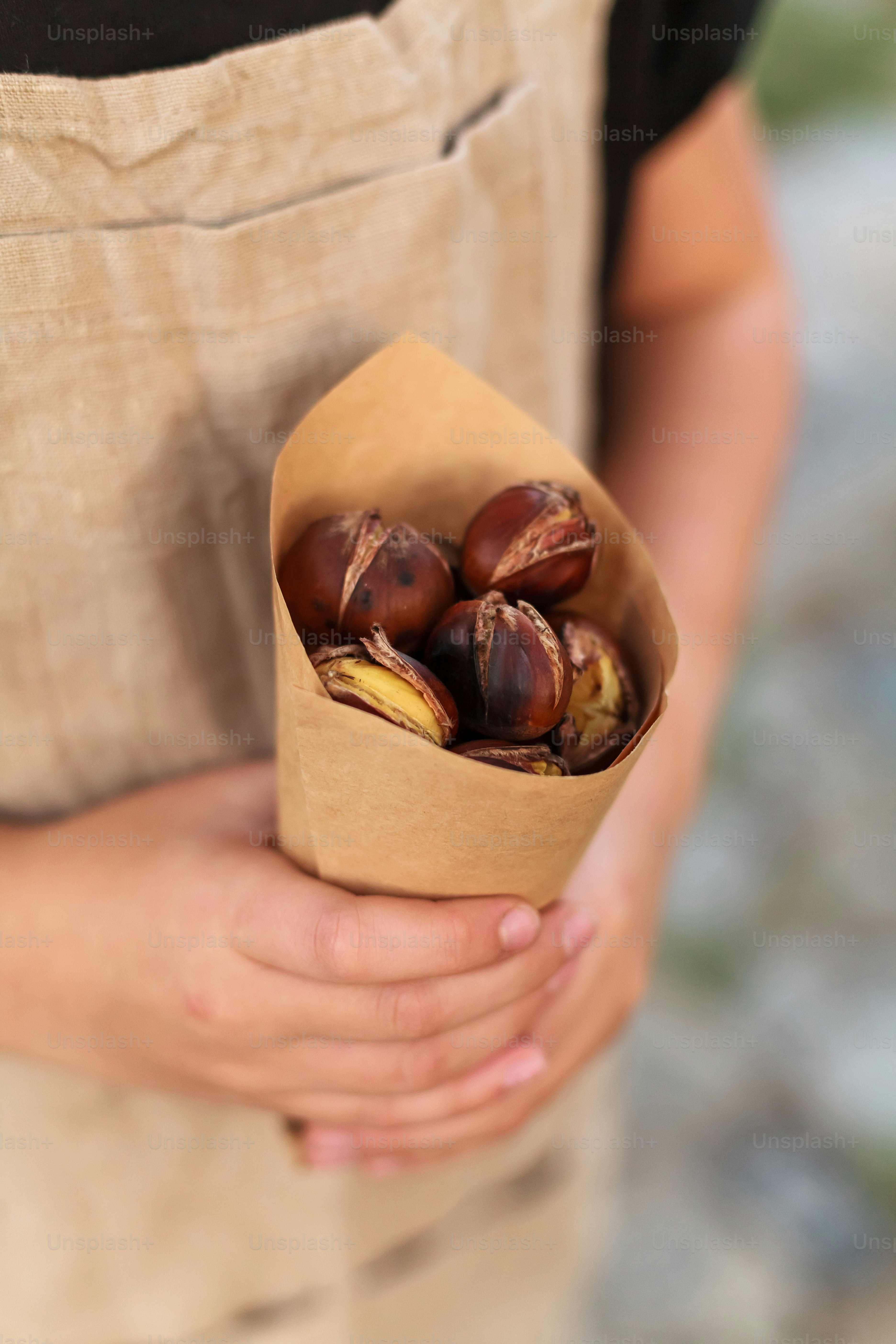 a person holding a paper bag filled with nuts