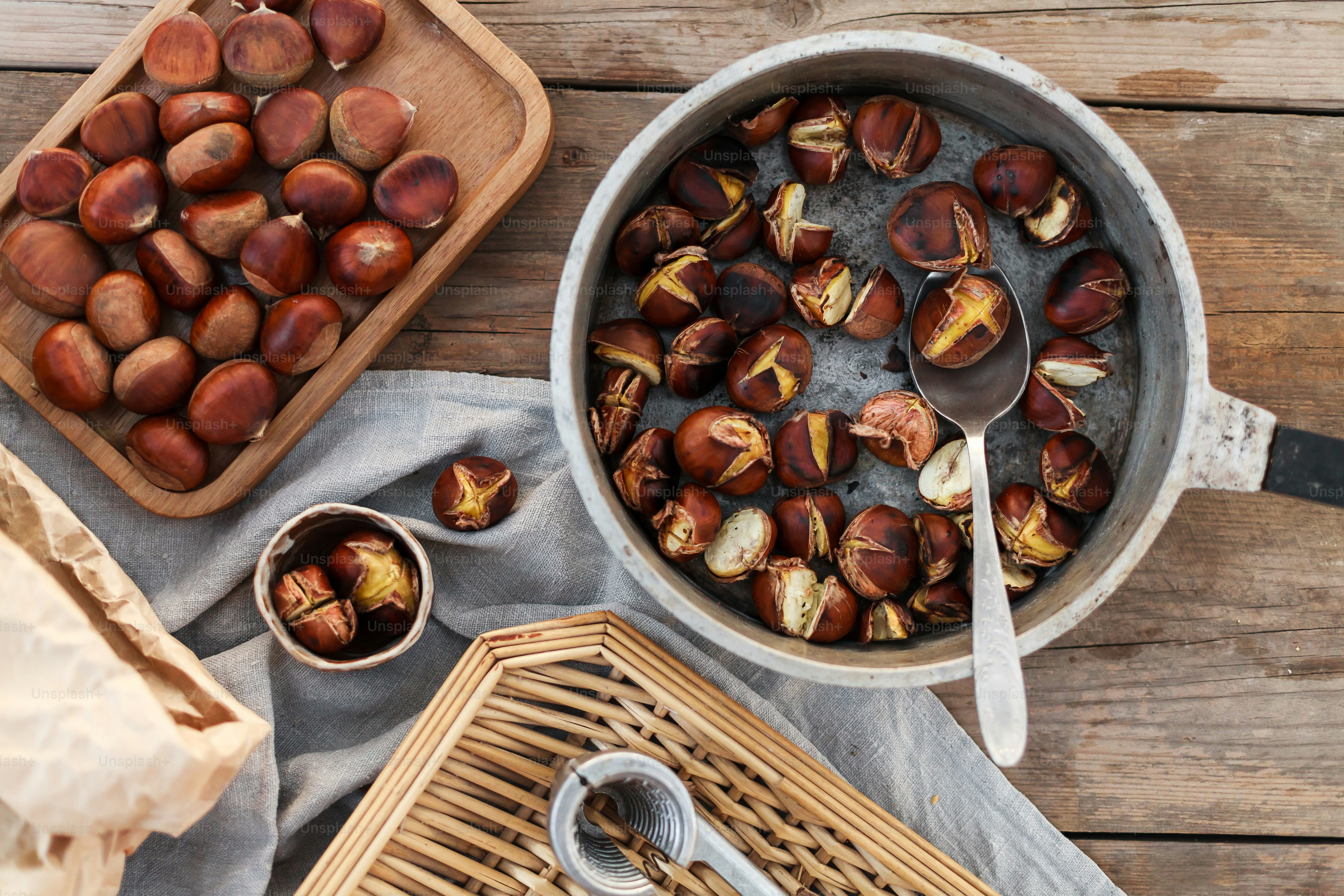 a bowl of chestnuts next to a basket of nuts