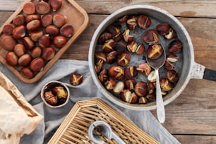 a bowl of chestnuts next to a basket of nuts