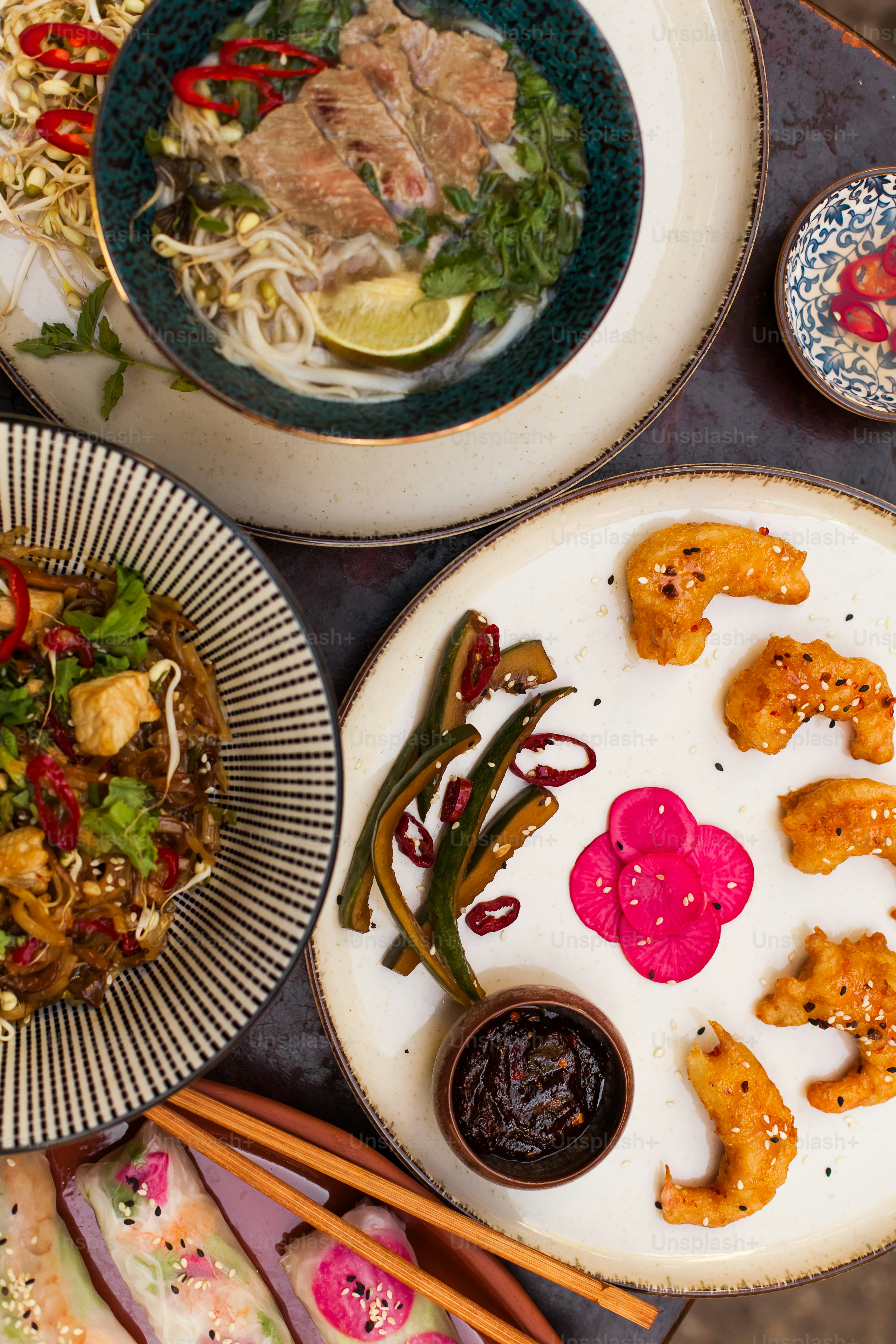 ein Tisch mit Tellern mit Essen und Essstäbchen
