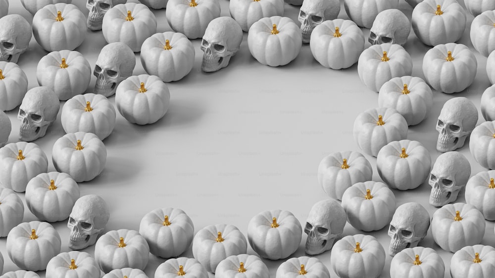 a group of white pumpkins with skulls on them