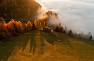 an aerial view of a foggy mountain with a house in the foreground