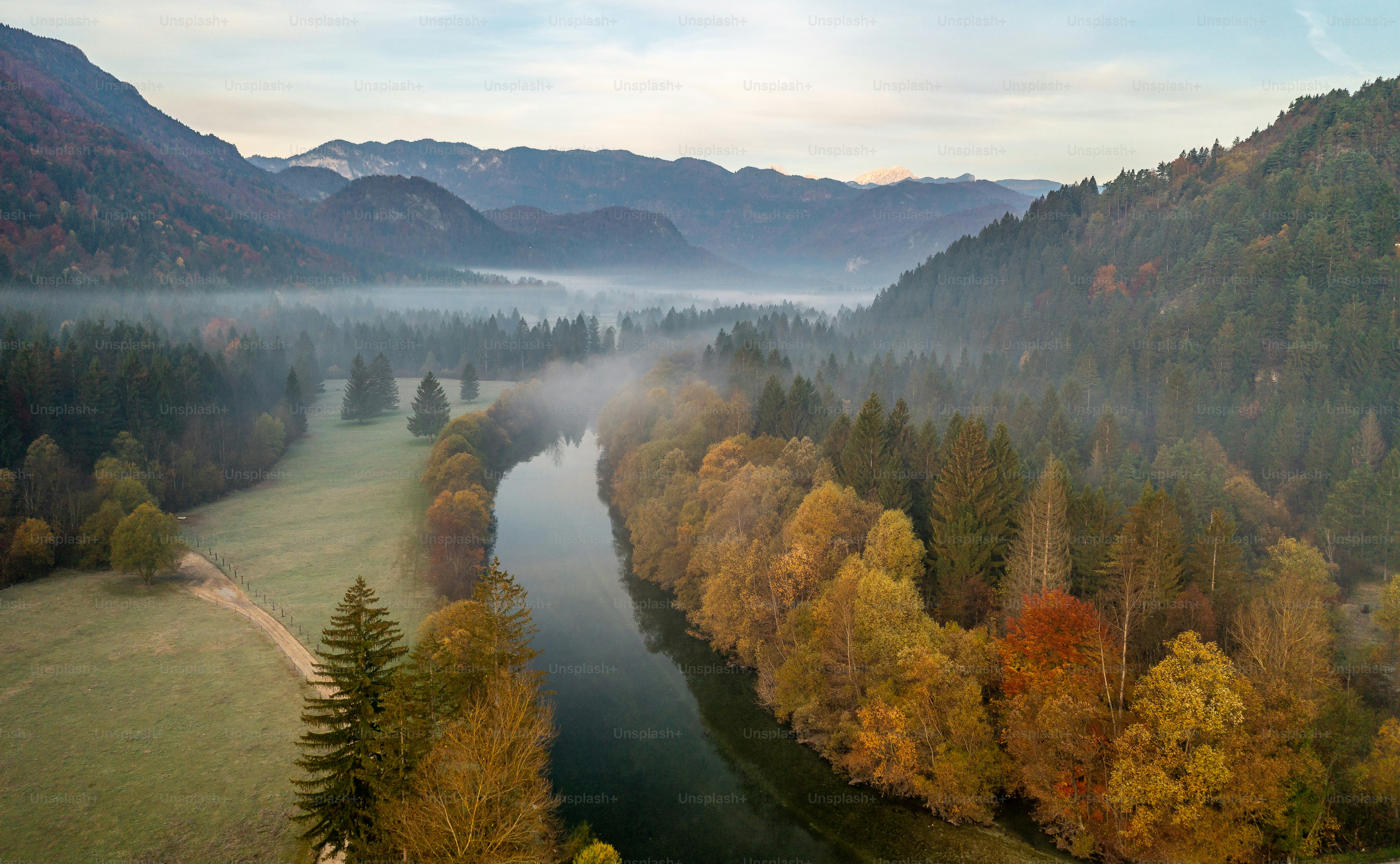 An aerial view of a river surrounded by trees photo – Autumn Image on ...