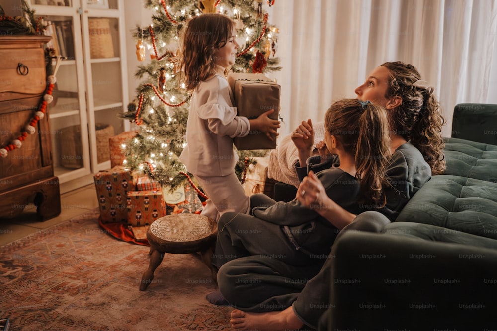 a group of children sitting around a christmas tree