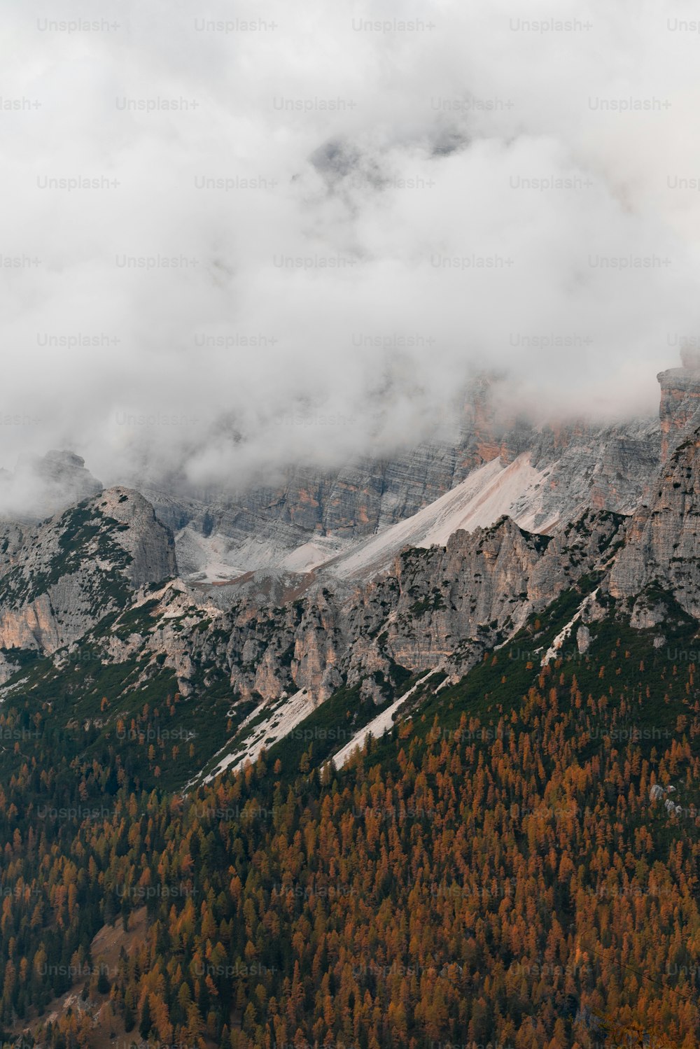 a mountain range covered in snow and clouds