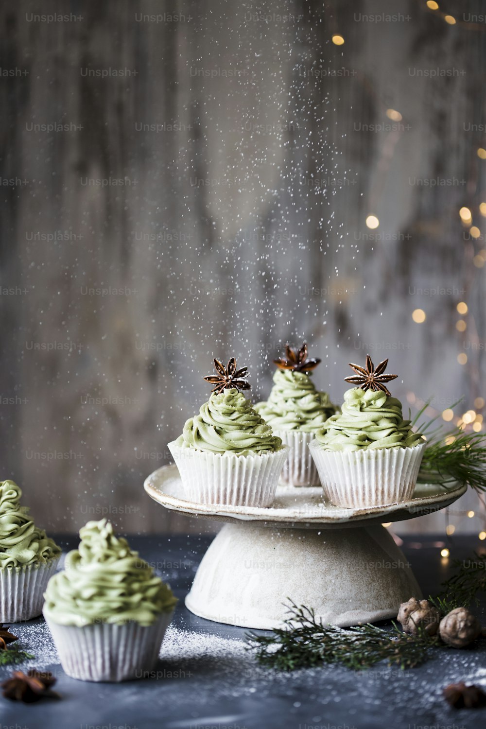 cupcakes with green frosting and sprinkles on a cake plate