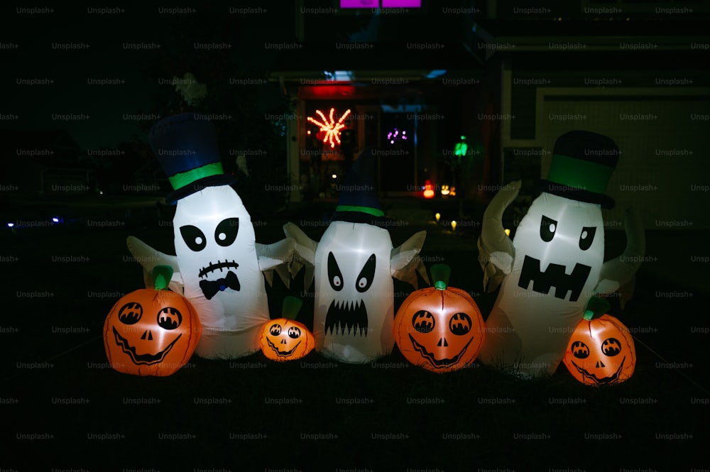 a group of halloween pumpkins sitting in front of a house