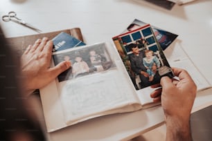 una persona sosteniendo un libro abierto a una foto familiar