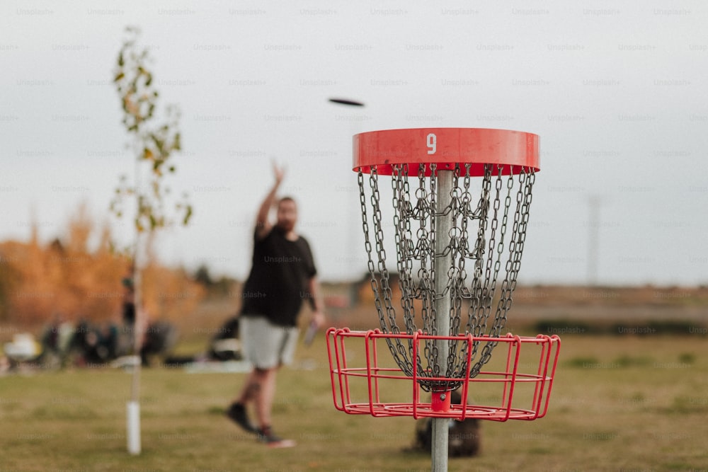 Un uomo che lancia un frisbee in un cesto da golf frisbee