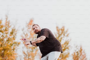 Un uomo con una camicia nera sta lanciando un frisbee