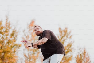 a man in a black shirt is throwing a frisbee