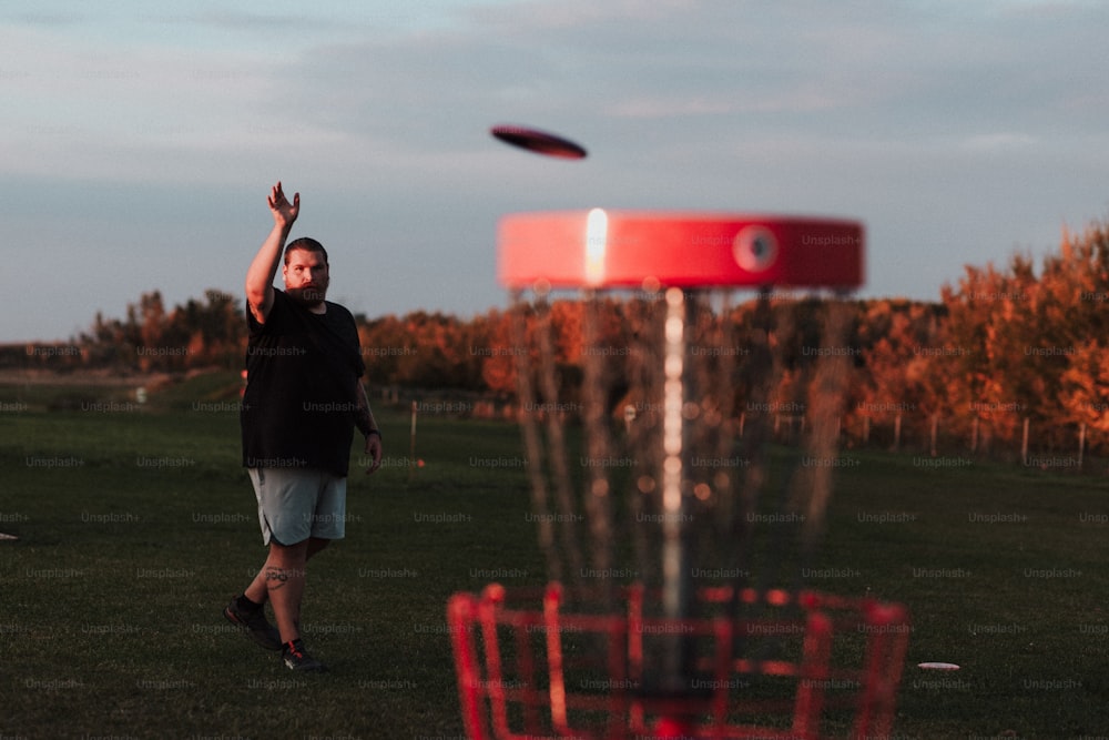 um homem jogando um frisbee em um campo