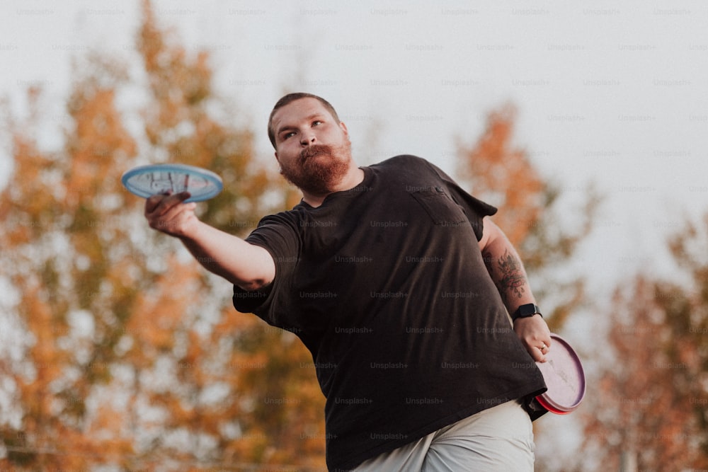 um homem segurando um frisbee na mão direita
