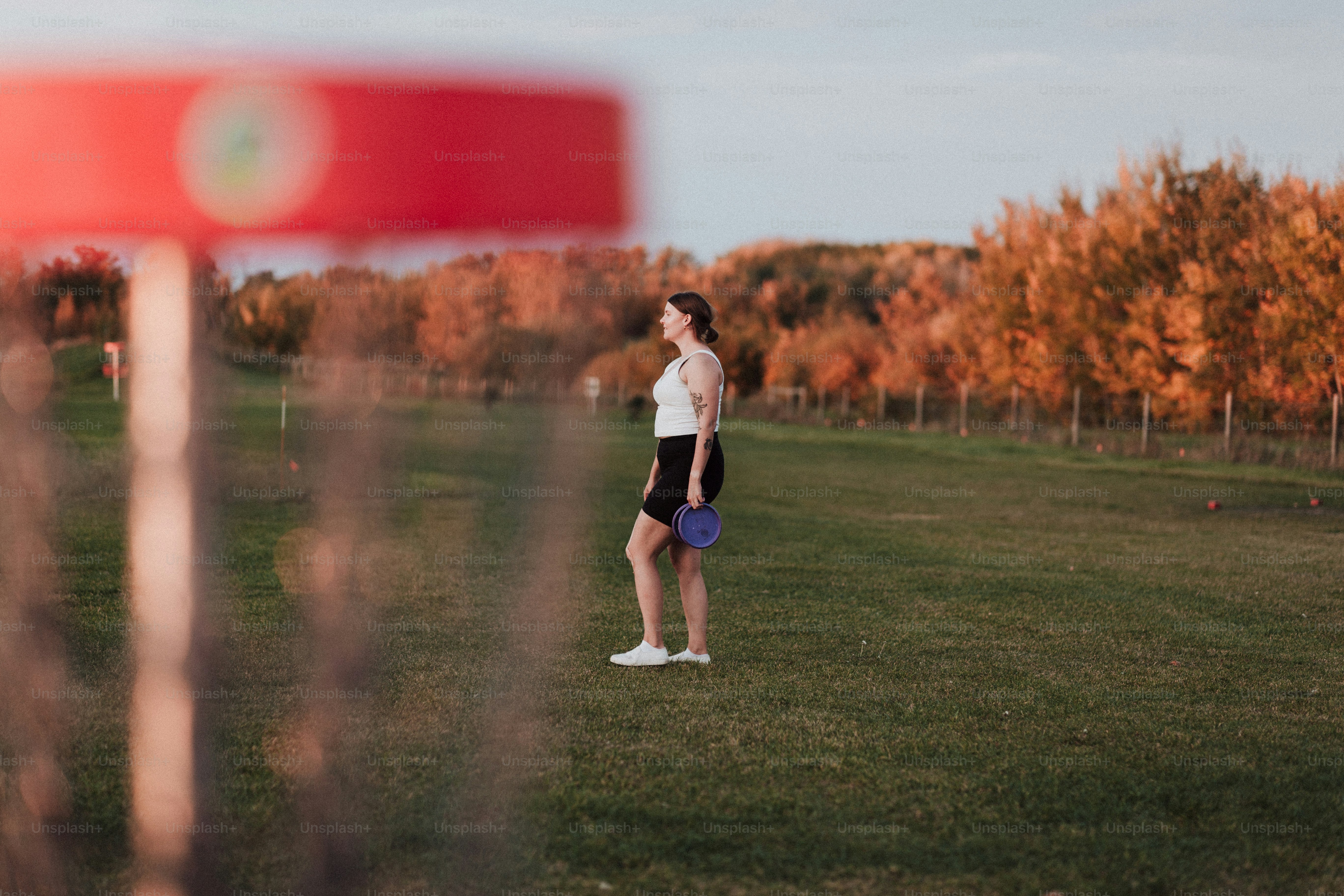 a woman standing in a field with a frisbee