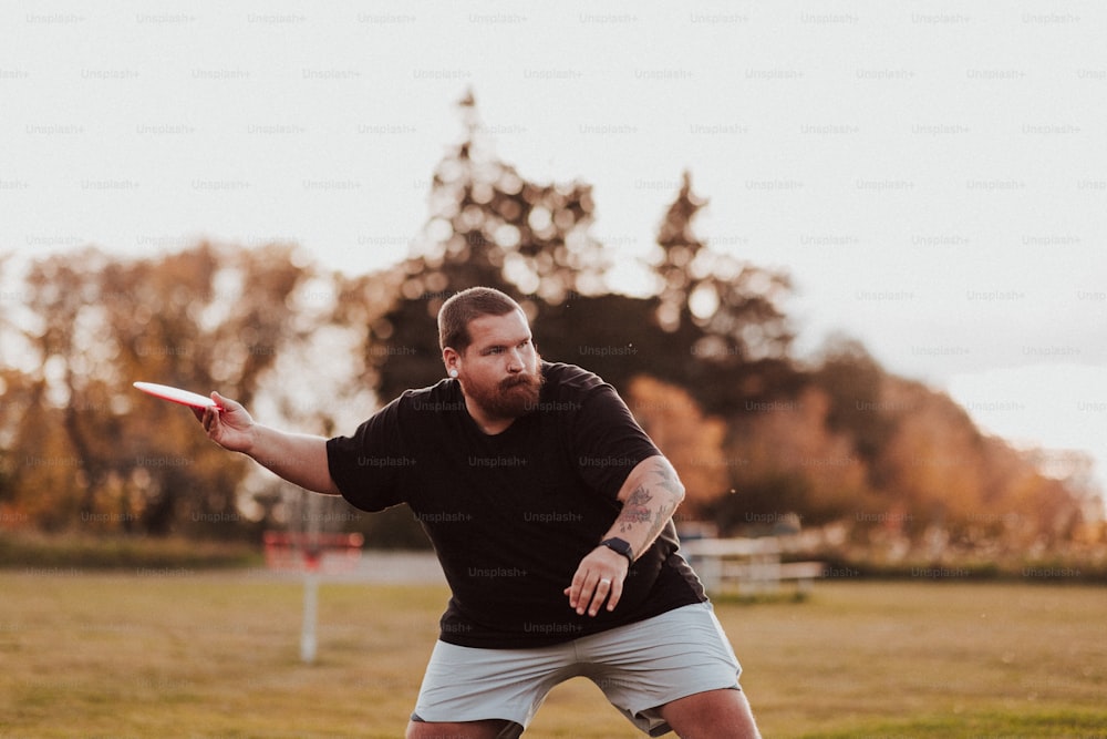 um homem jogando um frisbee em um campo