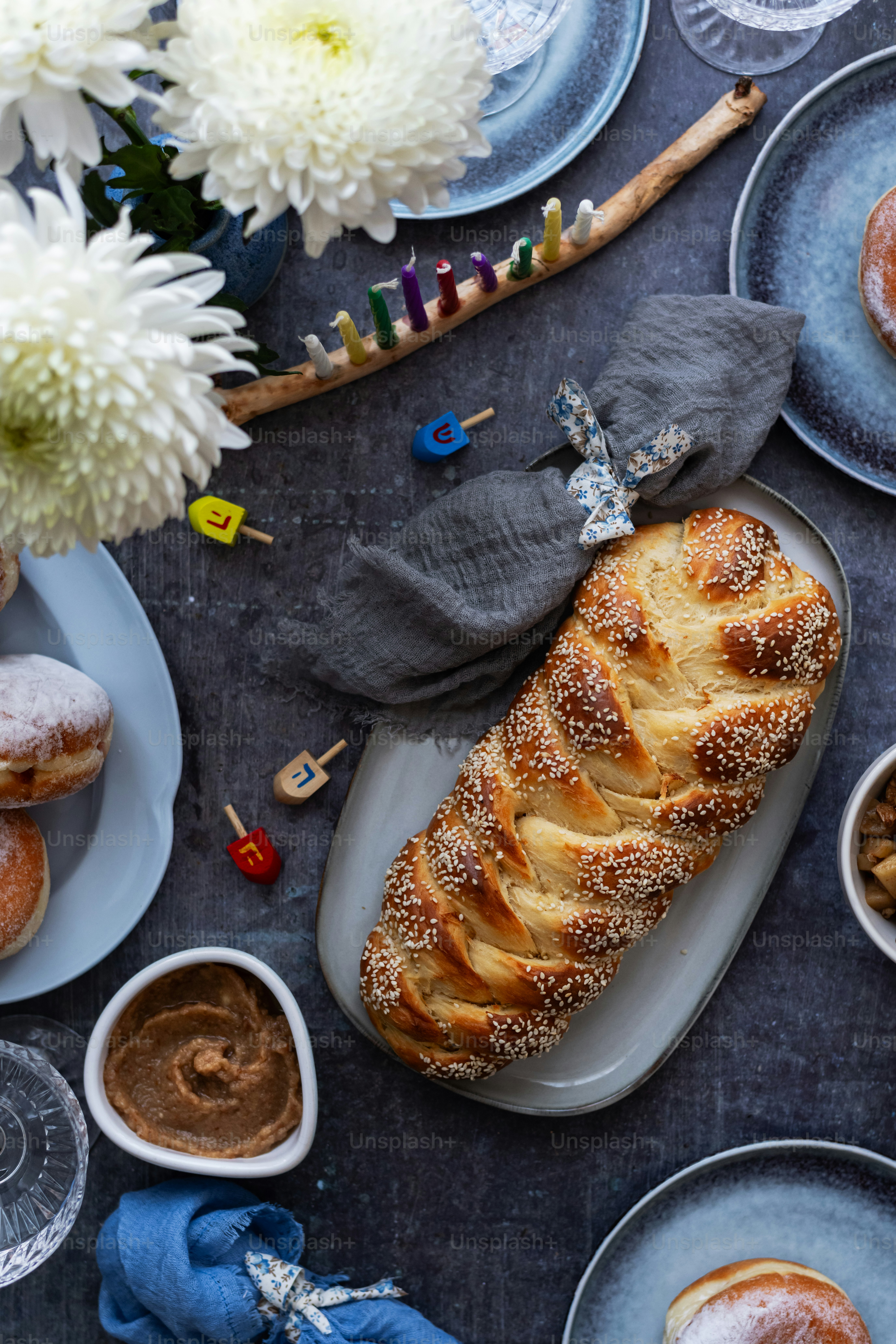 a table topped with plates of food and a loaf of bread