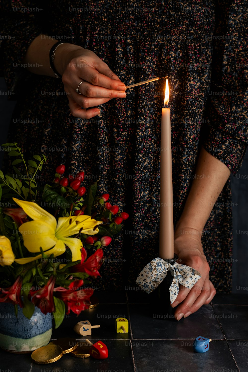 a person lighting a candle on a table