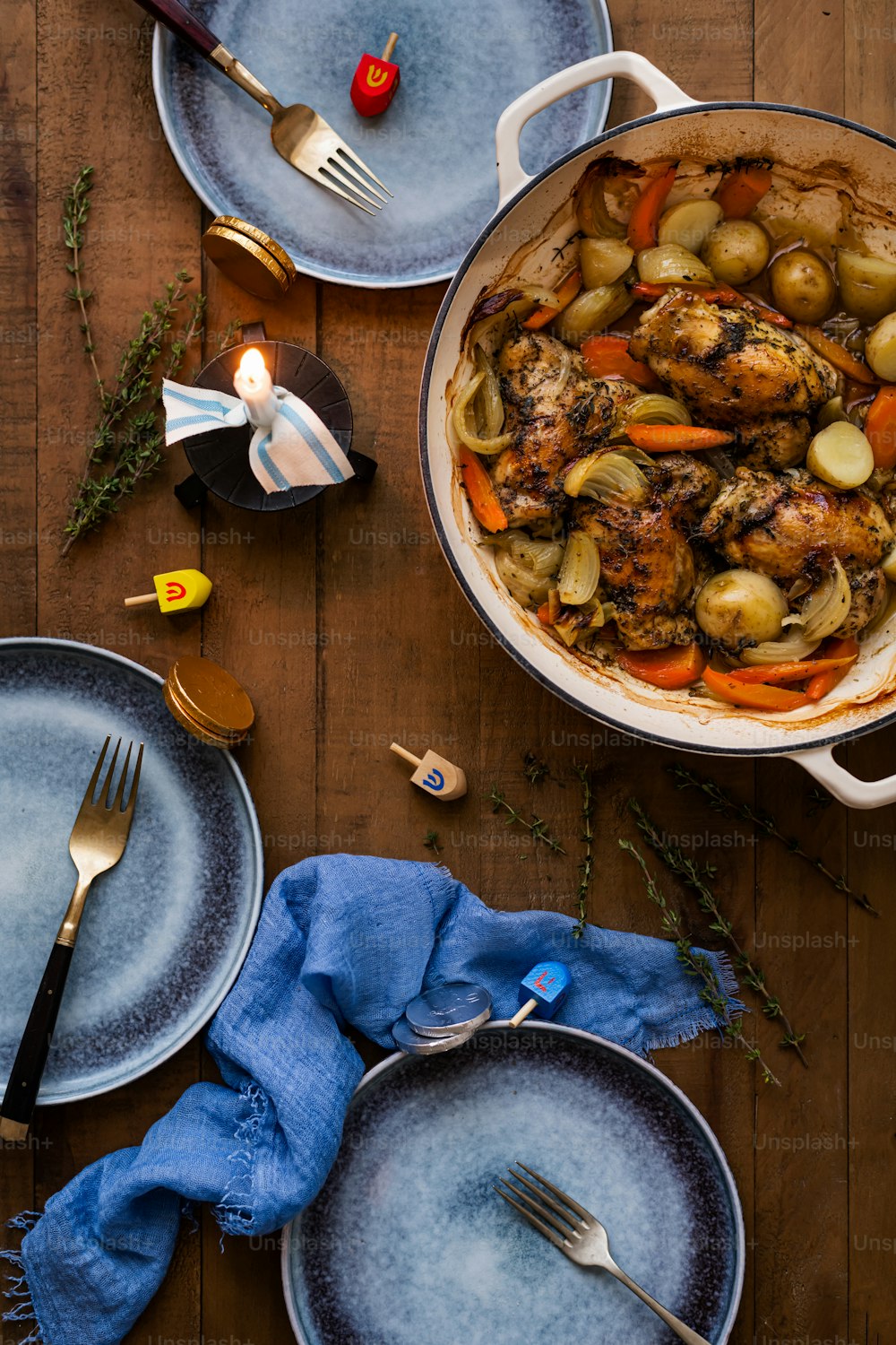 a table topped with plates of food and a pot of chicken