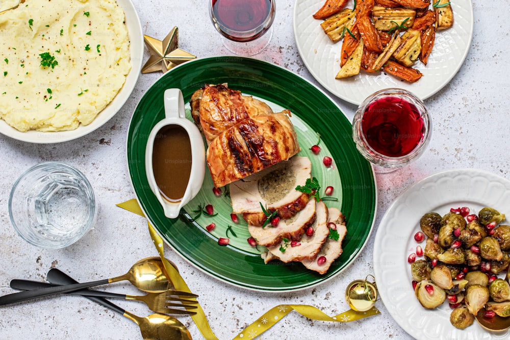 a green plate topped with meat next to a bowl of mashed potatoes