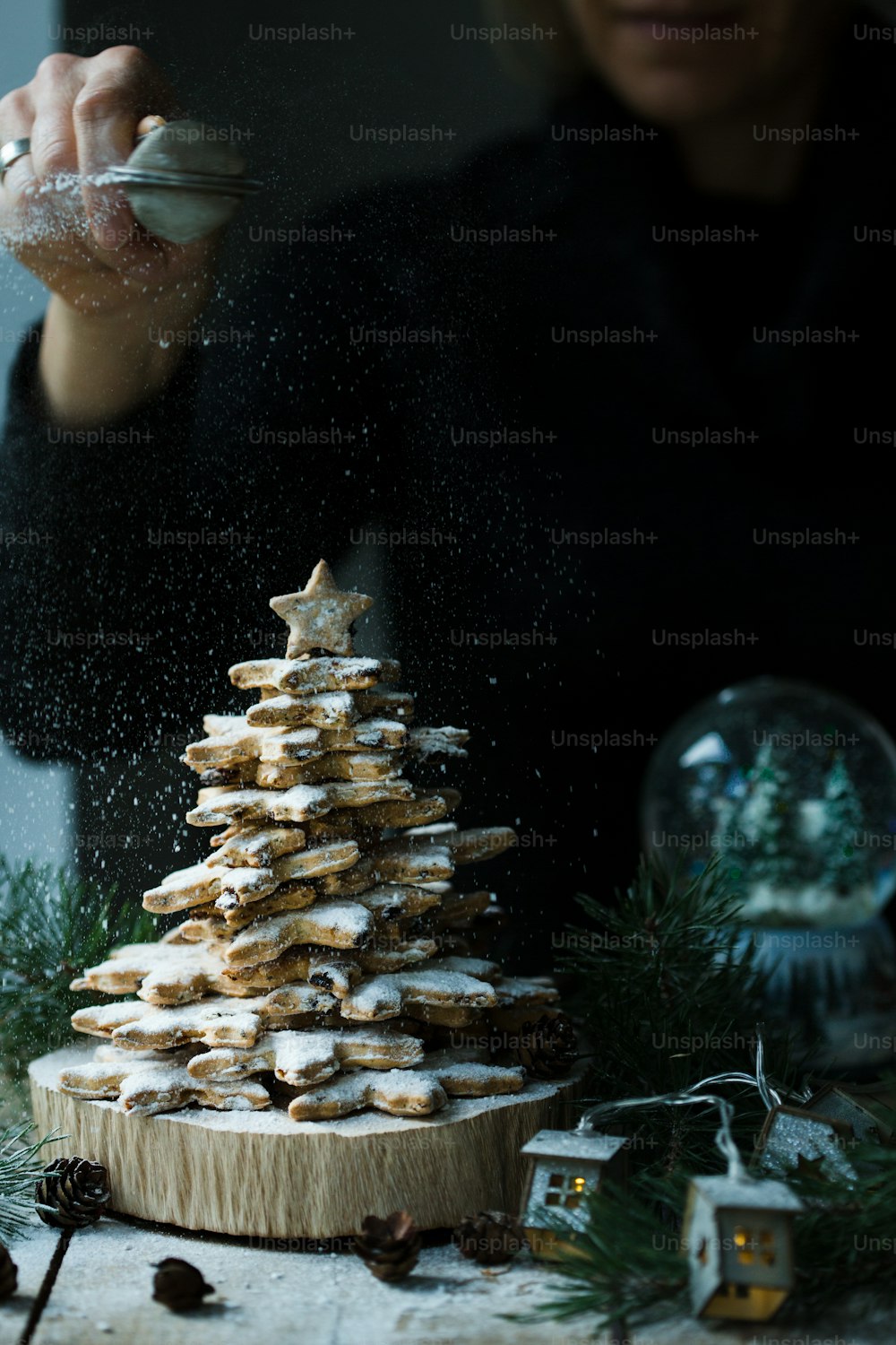 a woman sprinkling sugar on a christmas tree