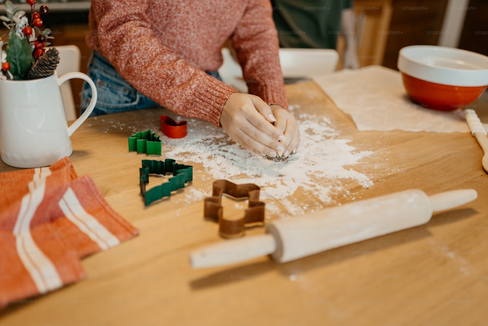 a woman is kneading dough on a table