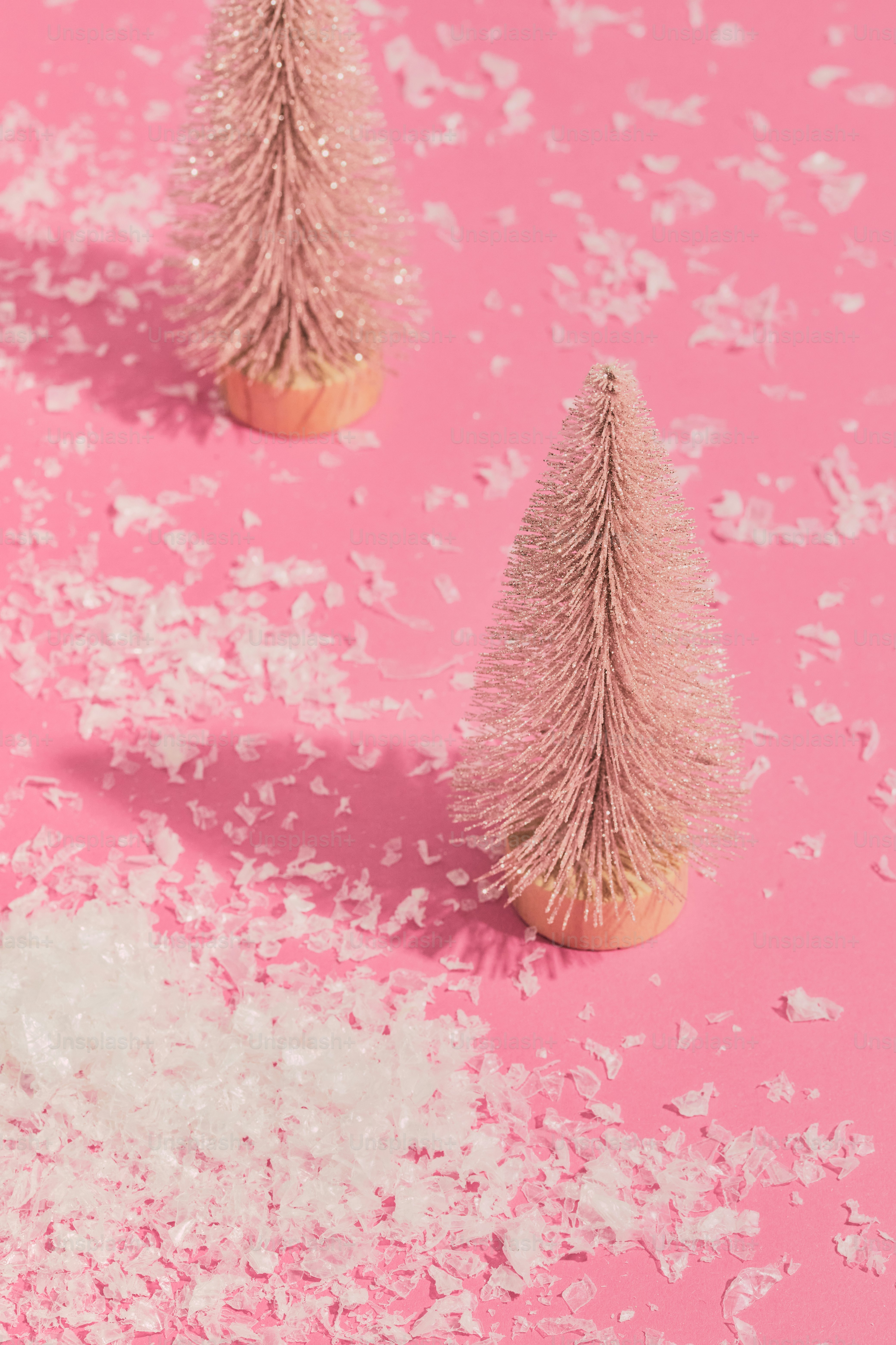 three small pink christmas trees on a pink background